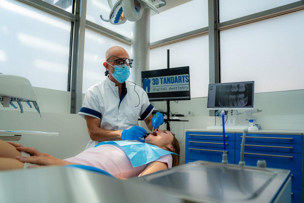 Dentista che tratta una paziente, con una scansione digitale sul monitor