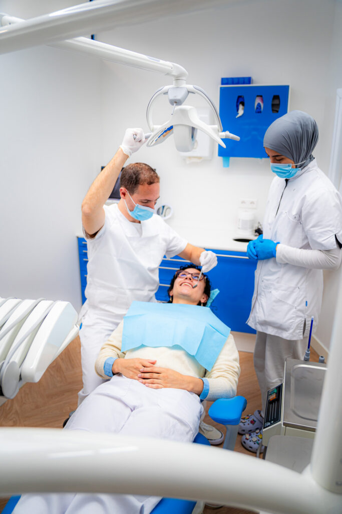 Dentist with treatment light and assistant during a treatment at 3D Tandarts