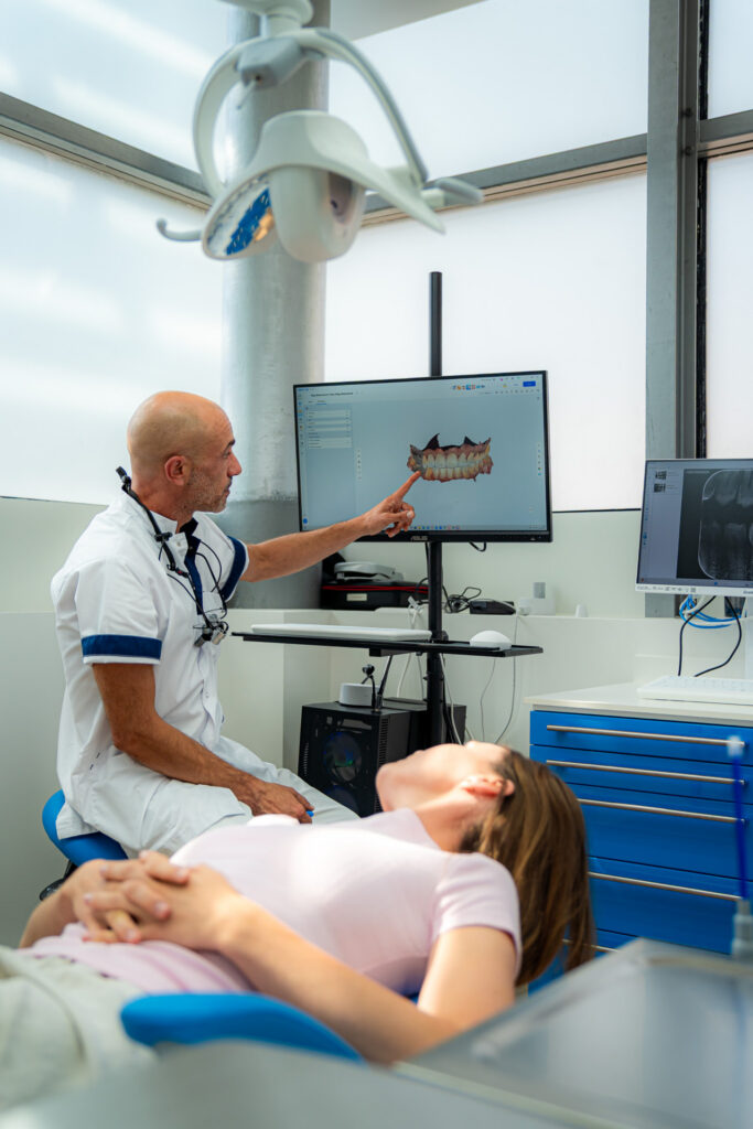 Dentista che esamina una scansione digitale della mascella sul monitor