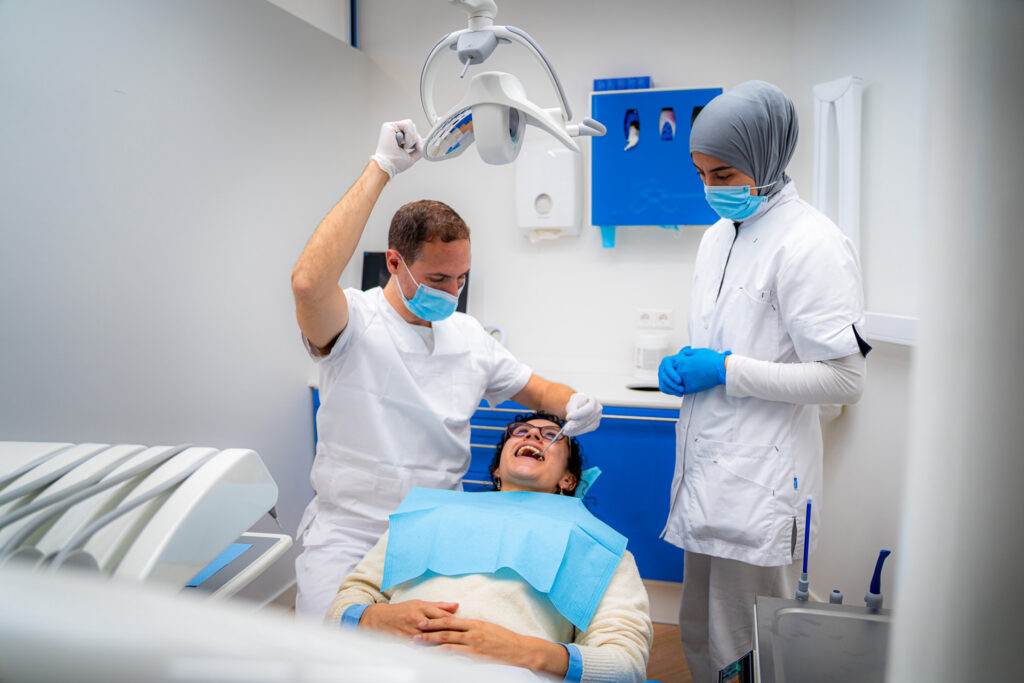 Dentista e assistente che trattano una paziente nella sala di trattamento di 3D Tandarts